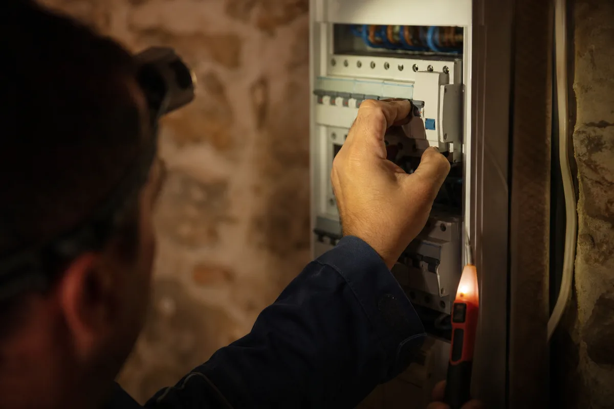 Tableau électrique ouvert dans une maison provençale, rangée de disjoncteurs