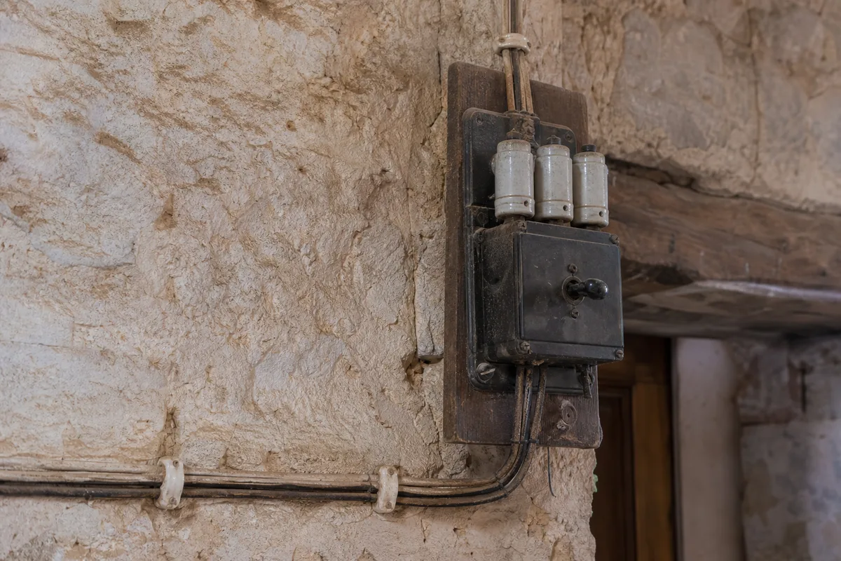 Ancien tableau électrique à porte-fusibles dans une maison de village varoise